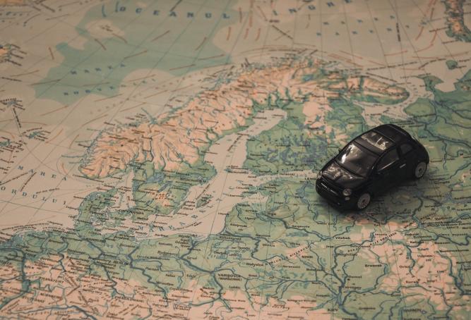 Black Toy Car on World Map Paper